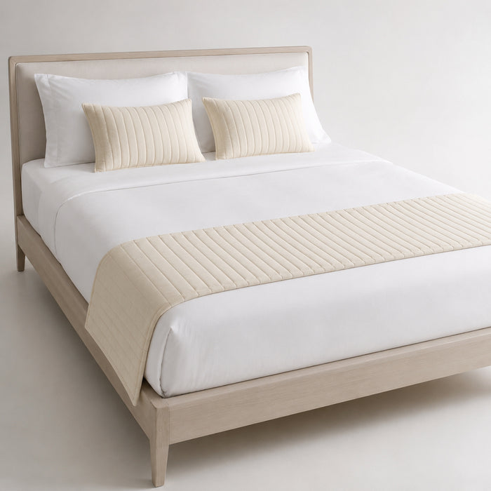 Ivory diamond-quilted bed runner styled on white bedding for wholesale hotel, resort and private-label bedroom sourcing