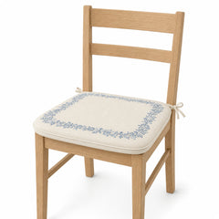 Primeval ivory and dusty blue floral border dining chair pad with tie straps on wooden dining chair