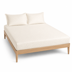 Ivory micro-diamond textured bed sheet set with matching pillowcases on a wooden bed