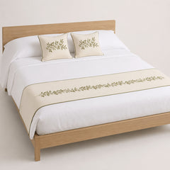 Ivory and olive botanical border bed runner styled on white bedding for wholesale resort, boutique hotel and private-label sourcing