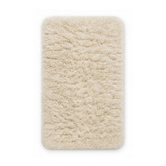 Ivory plush shag bath mat on white background