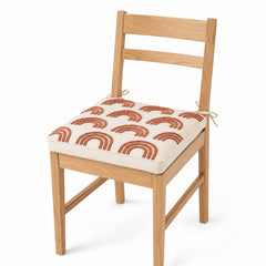 Primeval ivory and rust rainbow print dining chair pad with tie straps on wooden dining chair