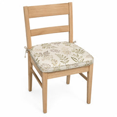 Primeval ivory and sage botanical print dining chair pad with tie straps on wooden dining chair