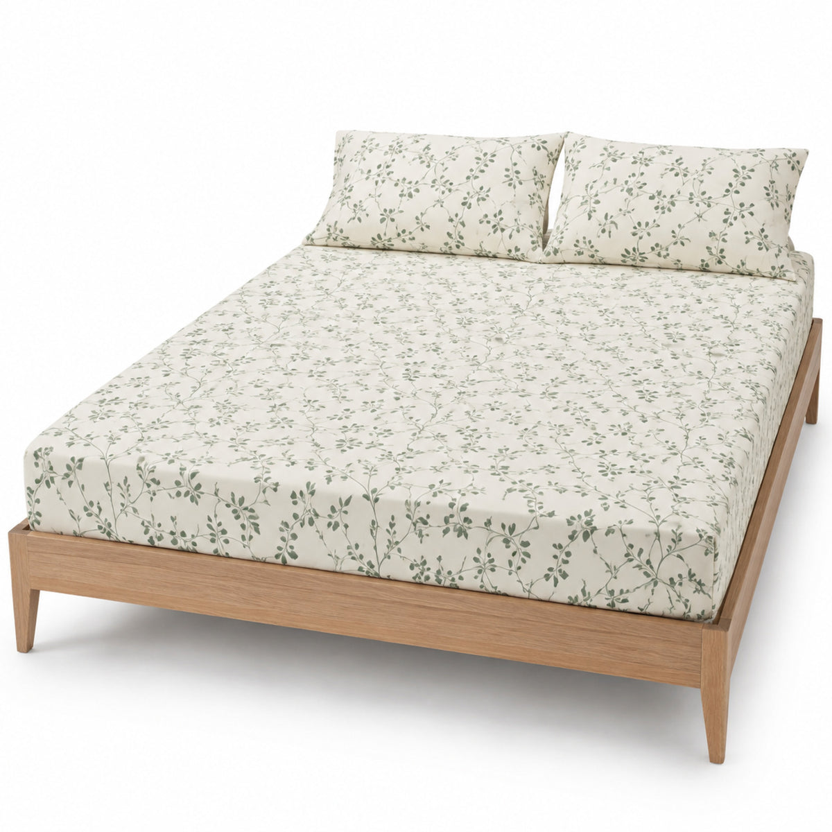 Ivory and sage botanical vine bed sheet set with matching pillowcases on a wooden bed