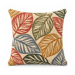 Primeval decorative throw cushion with coral red, mustard, olive green, and blue tropical leaves on a cream background, shown against a white background