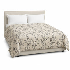 Primeval natural beige black botanical duvet cover displayed on a styled bed against a clean white studio background