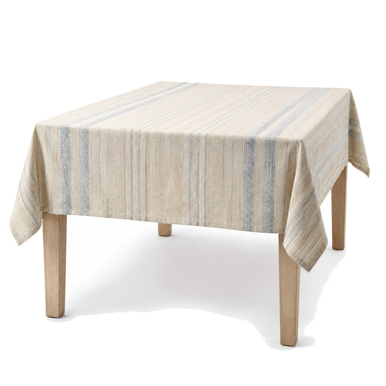 Primeval natural beige dusty blue ivory artisan stripe tablecloth displayed on a rectangular dining table