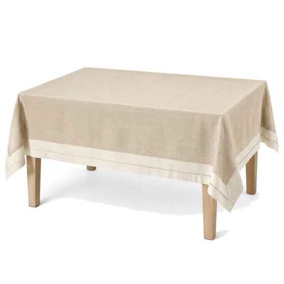 Primeval natural beige ivory border tablecloth displayed on a rectangular dining table