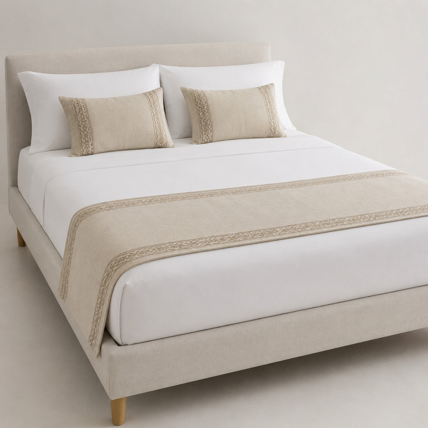 Natural beige minimalist border bed runner styled on white bedding for wholesale hotel, hospitality and private-label sourcing