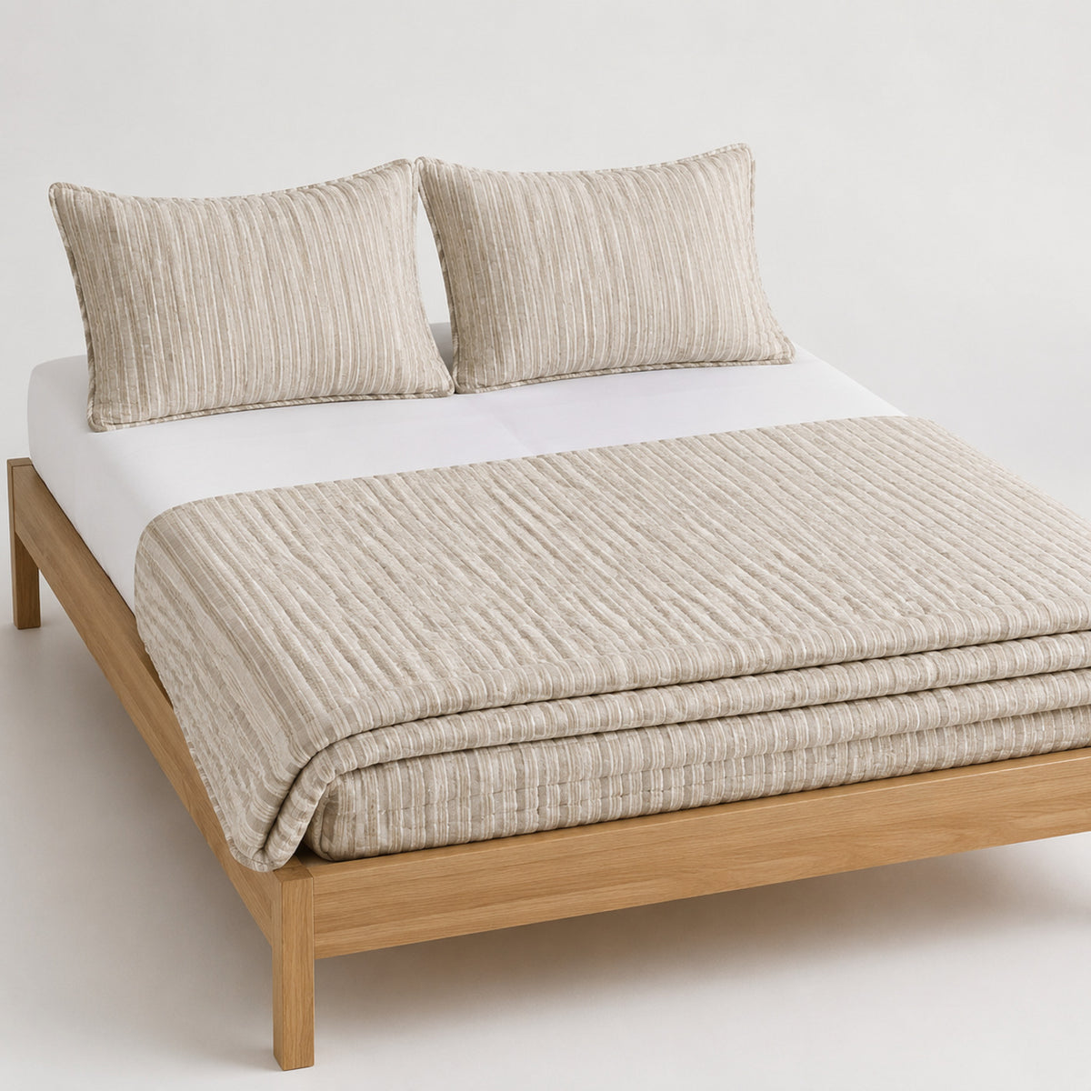 Natural cotton slub stripe quilt, folded with matching pillows for wholesale bedding sourcing