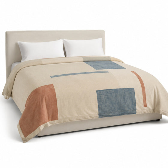 Primeval natural muted blue and rust abstract block duvet cover displayed on a styled bed against a clean white studio background