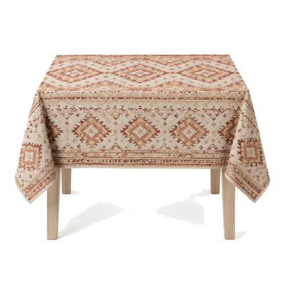 Primeval natural rust beige ivory tribal geometric tablecloth displayed on a rectangular dining table