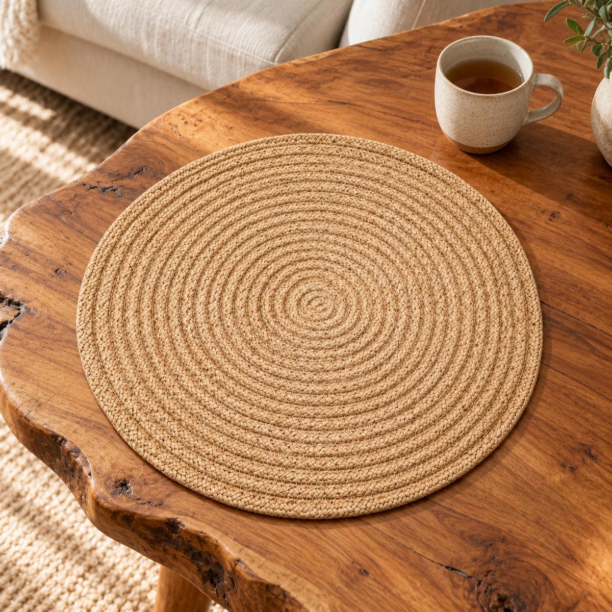 Natural beige spiral woven round placemat styled on a rustic wooden dining table