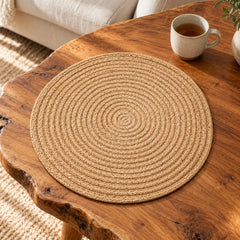 Natural beige spiral woven round placemat styled on a rustic wooden dining table