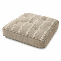 Natural beige floor cushion with raised vertical stripe tufting on white background