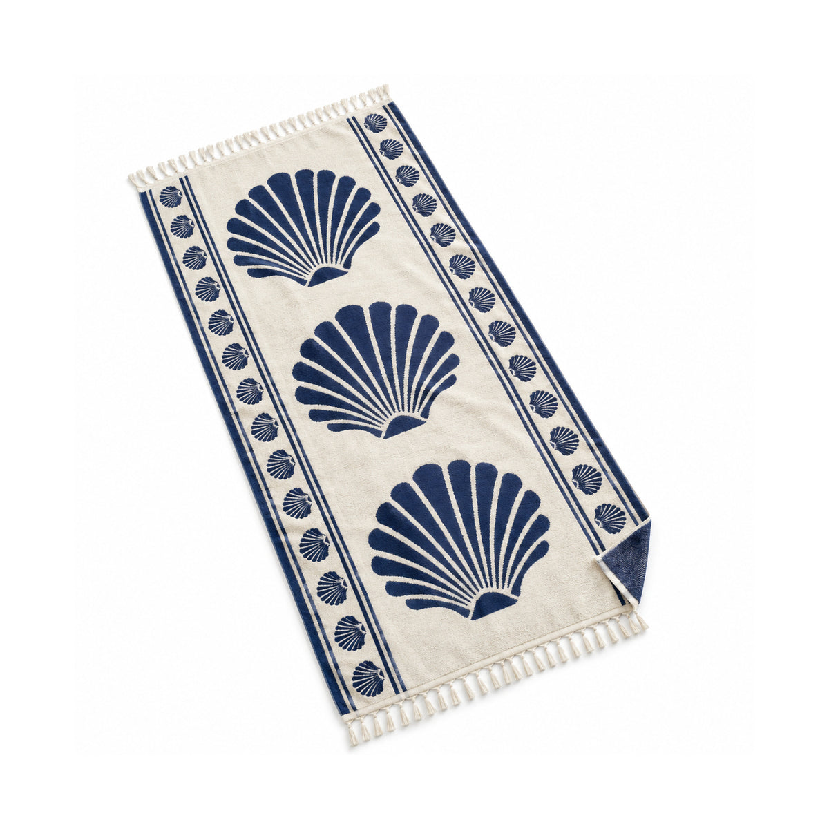 Ivory fringed beach towel with navy seashell print and decorative border.