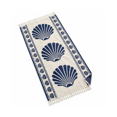 Ivory fringed beach towel with navy seashell print and decorative border.