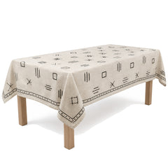 Primeval oatmeal black linear embroidery tablecloth displayed on a rectangular dining table