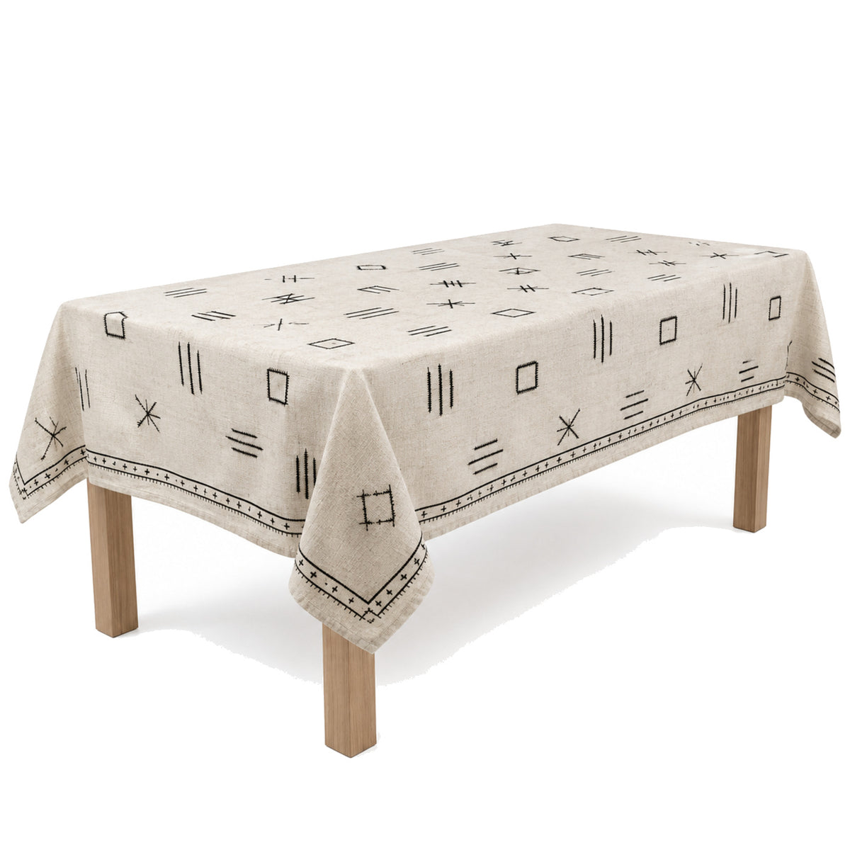 Primeval oatmeal black linear embroidery tablecloth displayed on a rectangular dining table