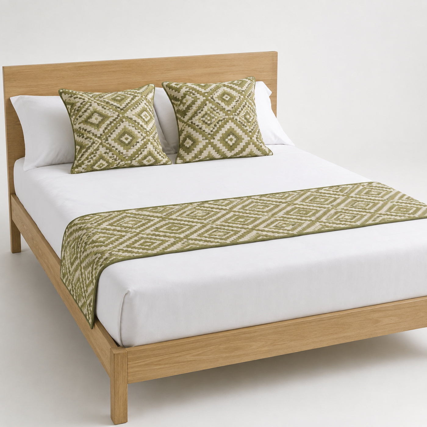 Olive diamond geometric bed runner styled on white bedding for wholesale resort, boutique hotel and private-label sourcing