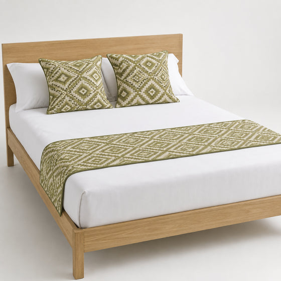 Olive diamond geometric bed runner styled on white bedding for wholesale resort, boutique hotel and private-label sourcing