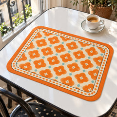 Orange and white floral tile print rectangular placemat on a modern white dining table