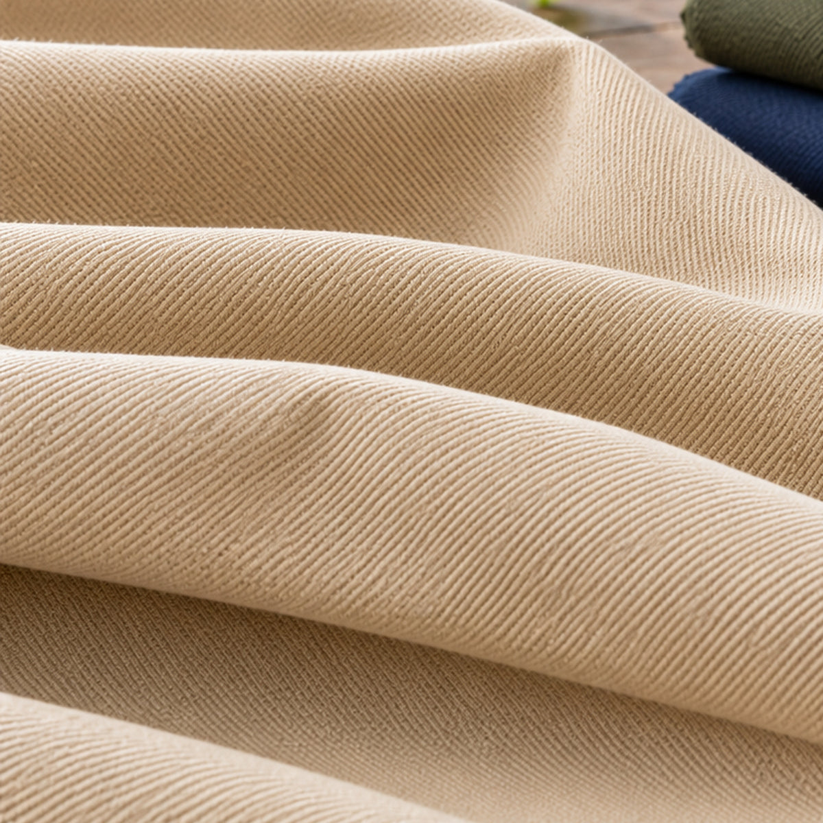 Beige cotton drill fabric with characteristic diagonal twill surface and folded shade references; Primeval fabric sourcing reference PML-FAB-012