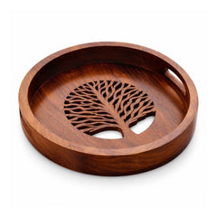 Round dark wooden tray with raised rim, oval cutout side handles and decorative tree silhouette cutout in the base