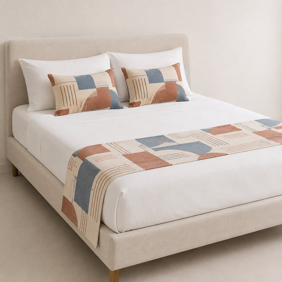 Rust, blue and grey colorblock bed runner styled on white bedding for wholesale contemporary hotel and private-label sourcing