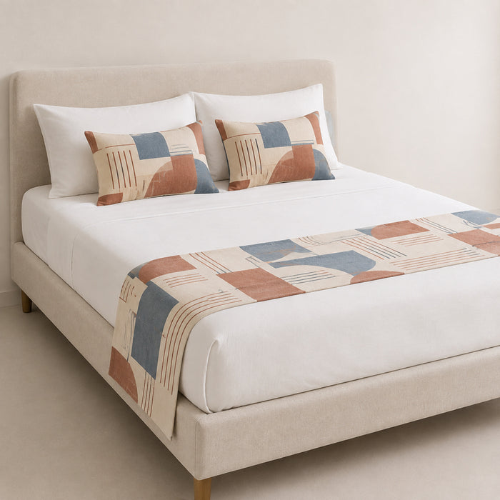 Rust, blue and grey colorblock bed runner styled on white bedding for wholesale contemporary hotel and private-label sourcing
