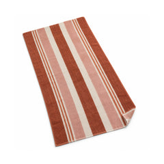 Rust, blush and cream mixed stripe beach towel on a white background.