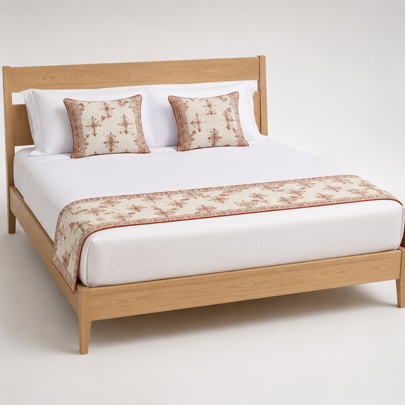 Rust botanical border bed runner styled on white bedding for wholesale boutique hotel, resort and private-label sourcing