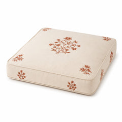 Ivory square floor cushion with rust floral block-style print on white background
