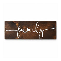 Rectangular rustic dark wooden wall sign with white handwritten-style family lettering across the center