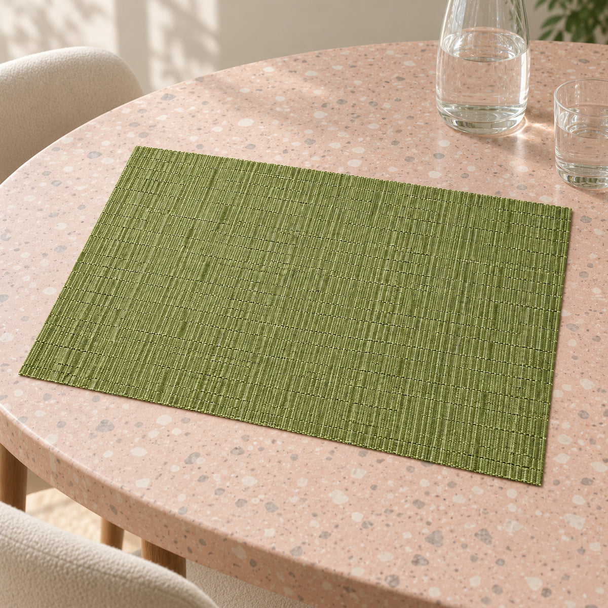Soft sage green rectangular placemat with fine parallel ribbed surface pattern on a light stone dining table