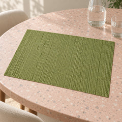 Soft sage green rectangular placemat with fine parallel ribbed surface pattern on a light stone dining table