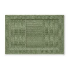 Sage green textured bath mat with framed woven panel design on white background