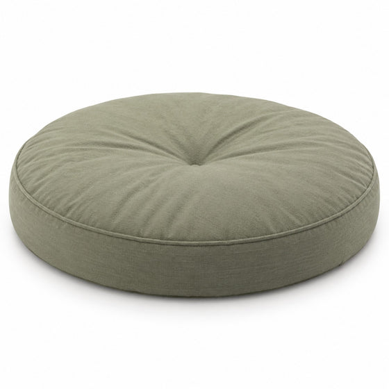 Sage green round floor cushion with central tufting on white background