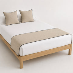 Taupe bed runner with dark contrast edge, presented on a white bed for wholesale hospitality and bedding collections