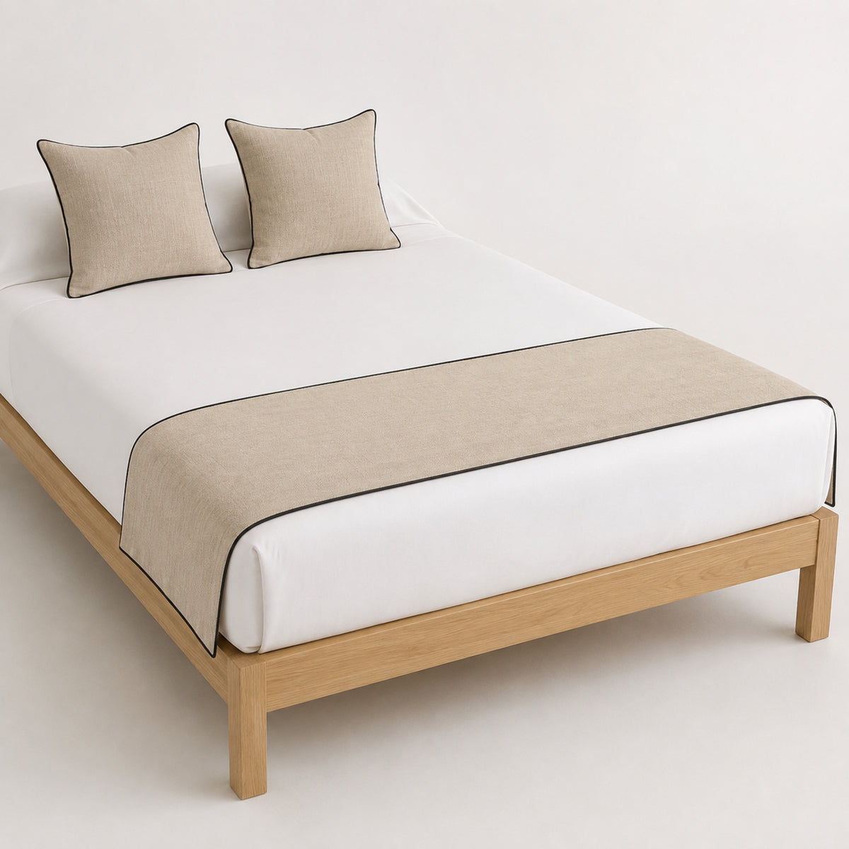 Taupe bed runner with dark contrast edge, presented on a white bed for wholesale hospitality and bedding collections