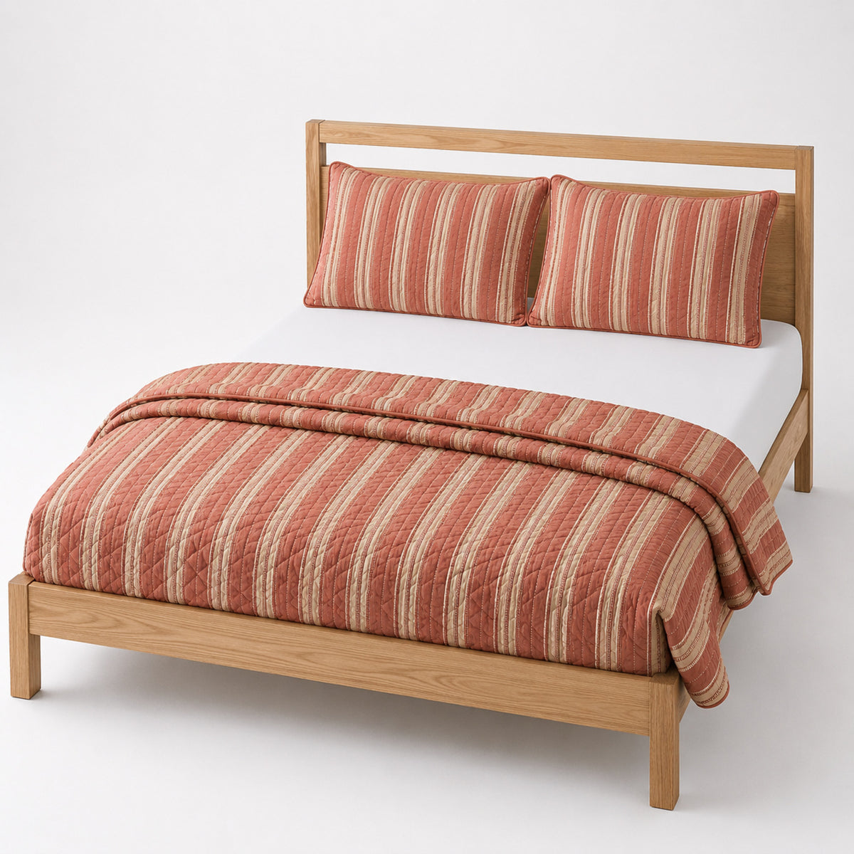 Terracotta and beige striped cotton quilt, folded with matching pillows for wholesale bedding sourcing