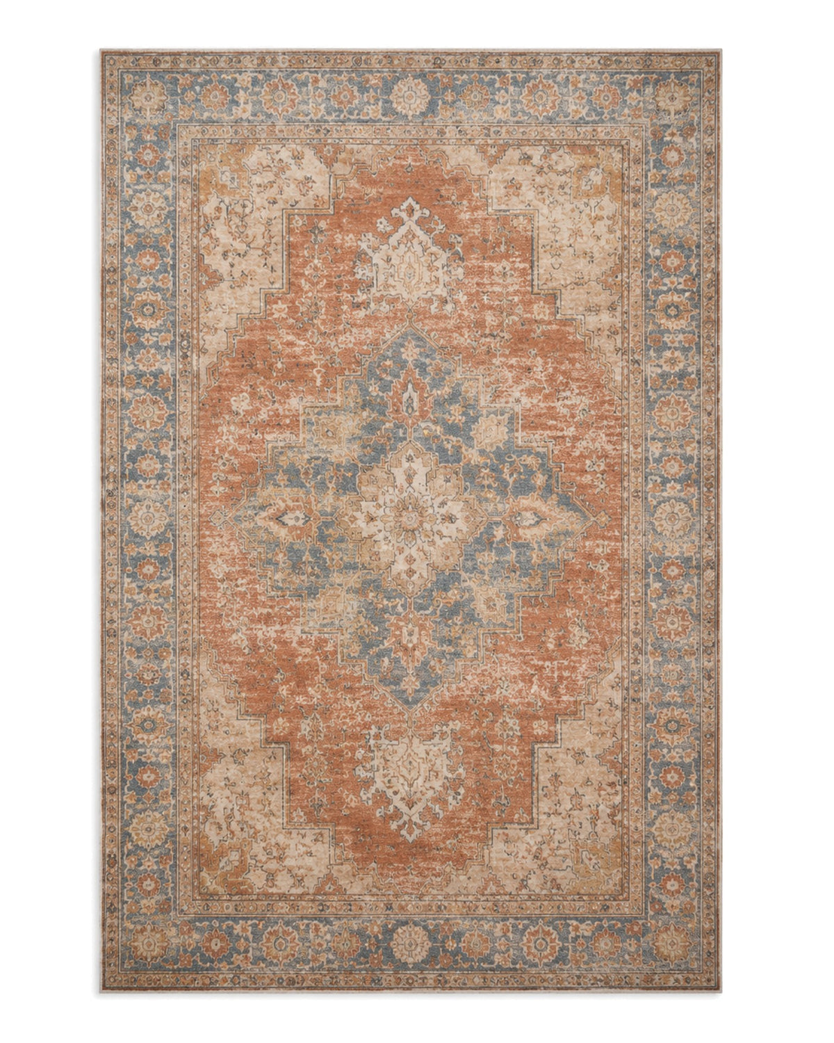 Faded terracotta and dusty blue printed area rug with a distressed central medallion and ornate border on a white background.