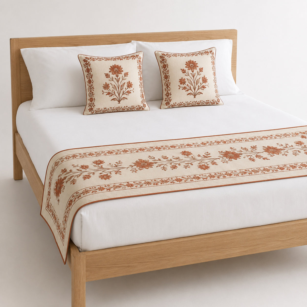 Terracotta floral block-print-inspired bed runner styled on white bedding for wholesale artisan, resort and private-label bedroom sourcing