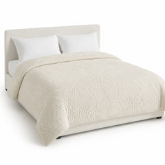 Primeval warm ivory sculpted tonal organic duvet cover displayed on a styled bed against a clean white studio background