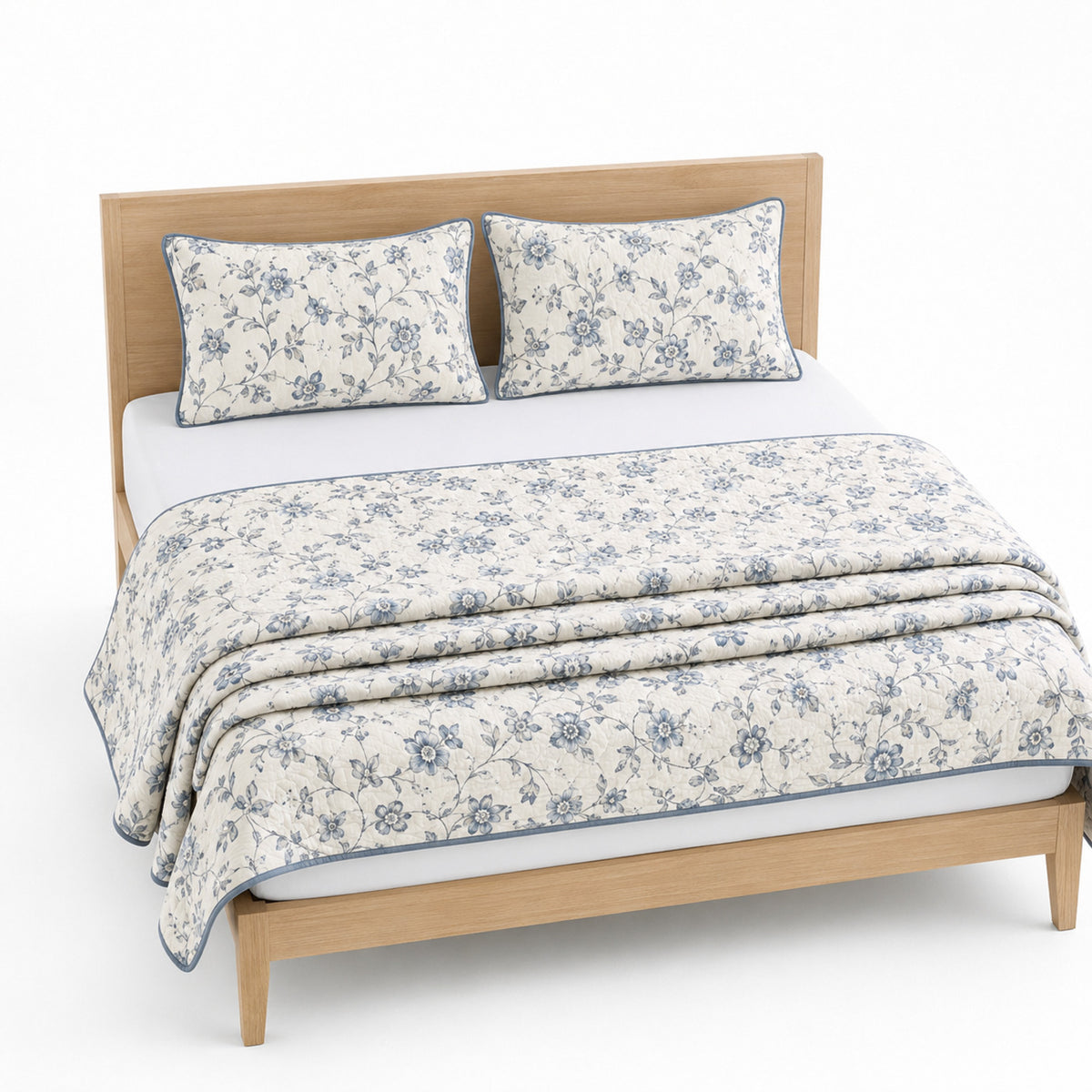 Warm white blue and grey floral cotton quilt, folded with matching pillows for wholesale bedding sourcing