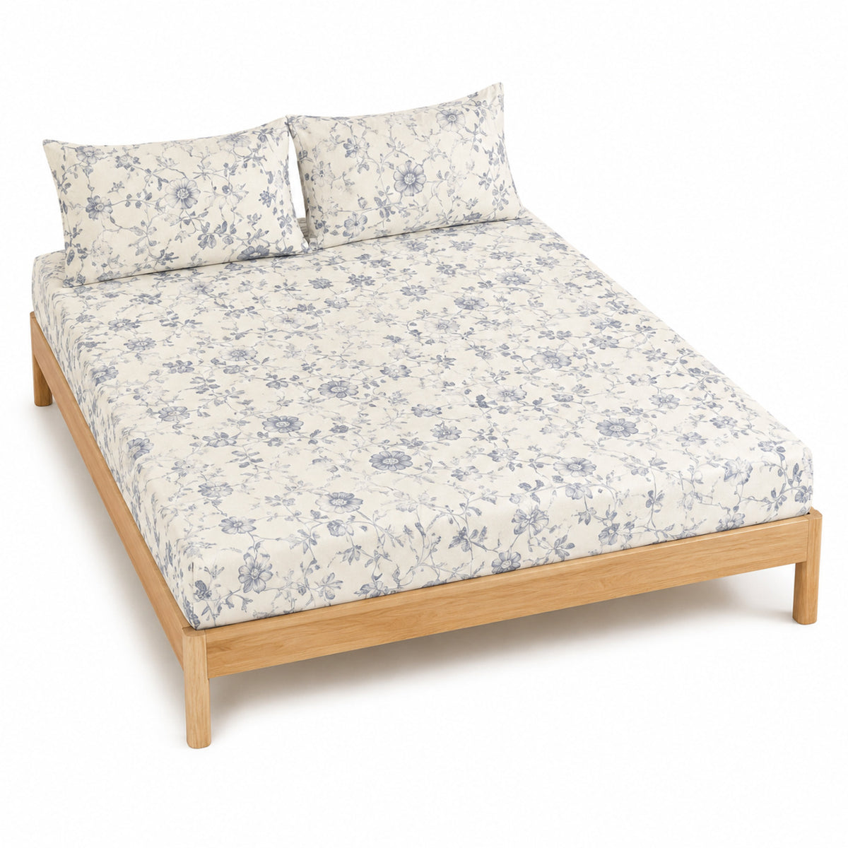 Warm white and blue grey floral vine bed sheet set with matching pillowcases on a wooden bed