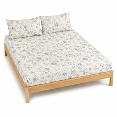 Warm white and blue grey floral vine bed sheet set with matching pillowcases on a wooden bed