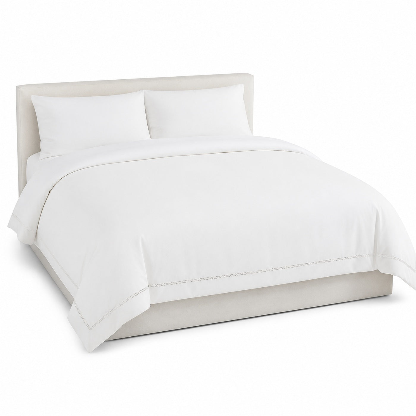 Primeval warm white decorative border duvet cover displayed on a styled bed against a clean white studio background