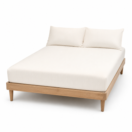 Warm white ribbed textured bed sheet set with matching pillowcases on a wooden bed