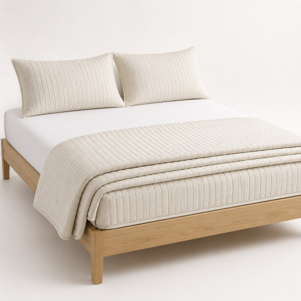Warm white tonal ribbed cotton quilt, folded with matching pillows for wholesale bedding sourcing
